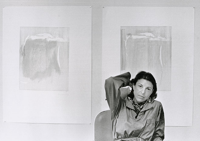 Portrait of Helen Frankenthaler in front of woodblock proofs for Essence Mulberry, 1977